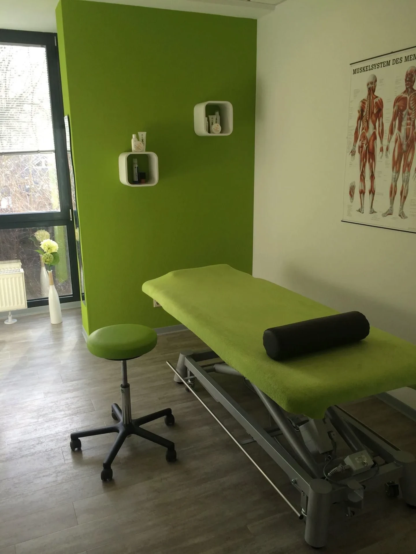 Behandlungsraum mit Muskelposter und Fenster bei Physio-Concept Dortmund