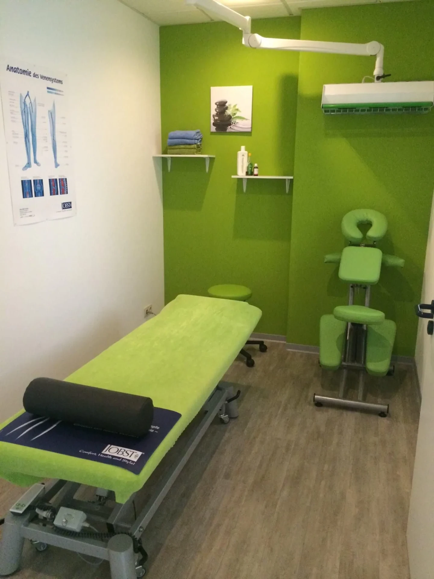 Behandlungsraum mit Therapieliege und Anatomie-Poster bei Physio-Concept Dortmund